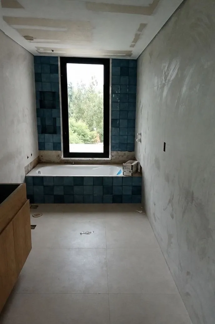 Baño antes de la reforma, con bañera alicatada en azul
