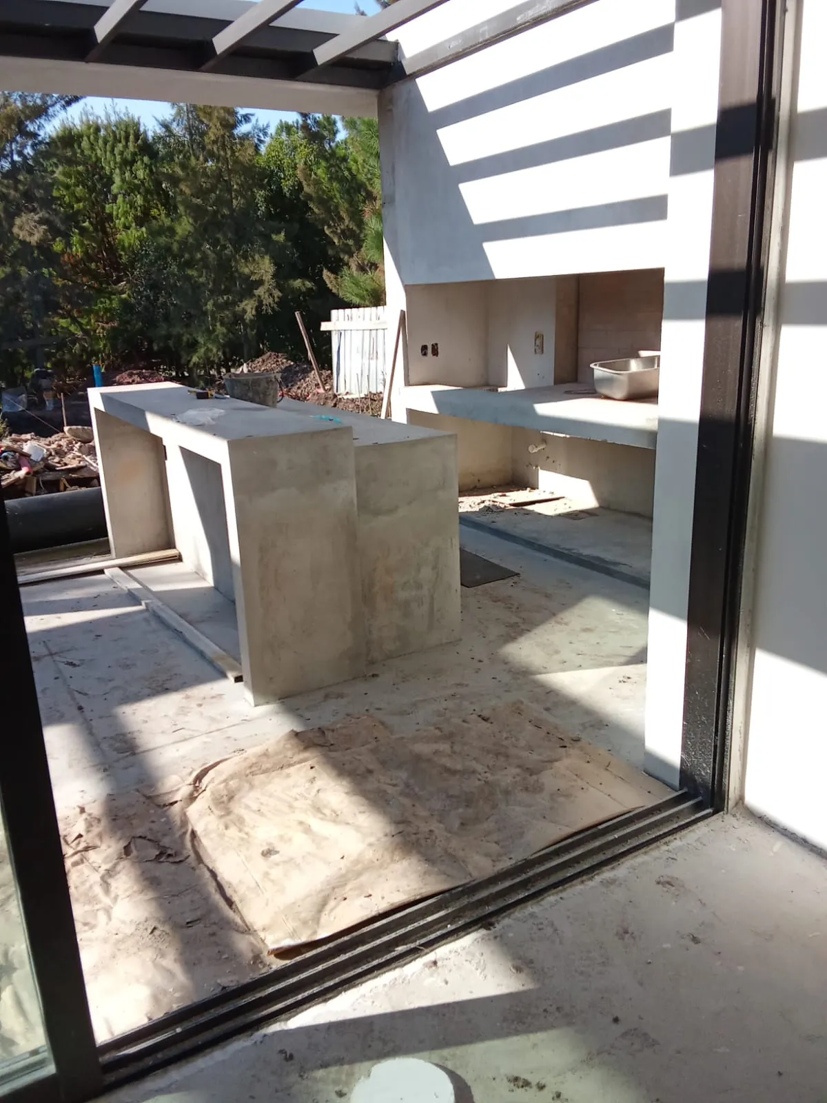 Cocina exterior de hormigón bajo la pérgola, durante la obra