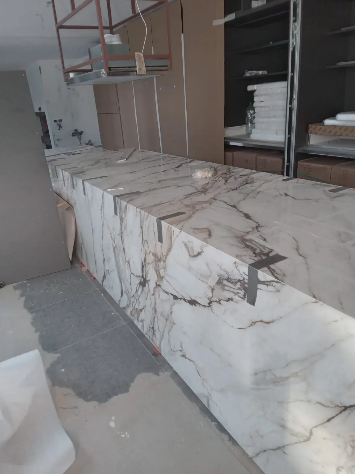 Isla de cocina revestida con piedra de vetas marrones durante el montaje