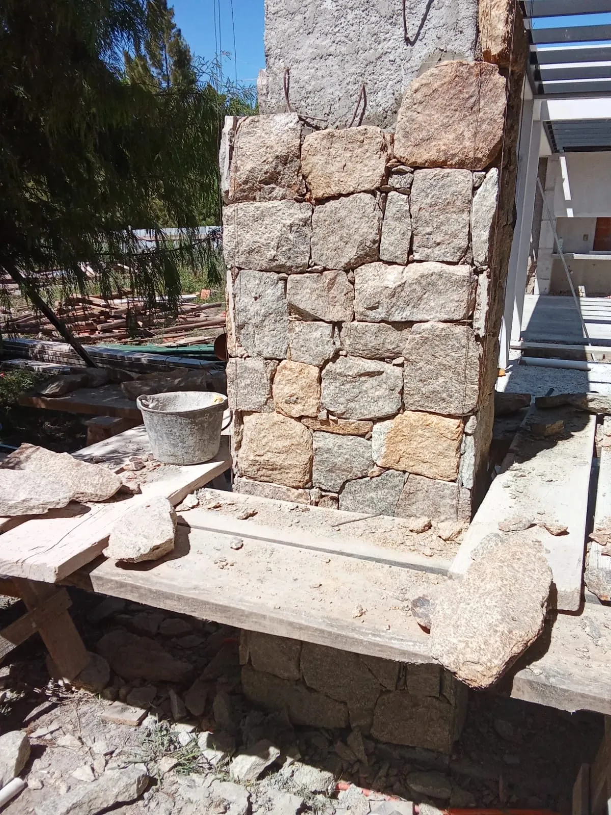 Pilar de hormigón revestido de piedra natural bajo una pérgola