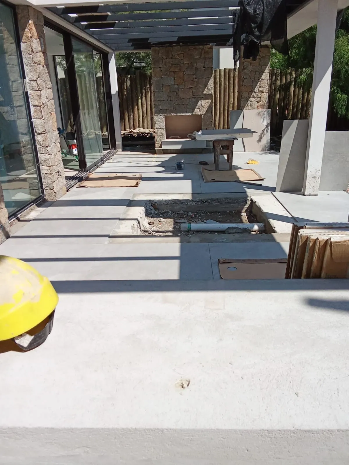 Solera de hormigón de un porche con pérgola metálica, durante la obra