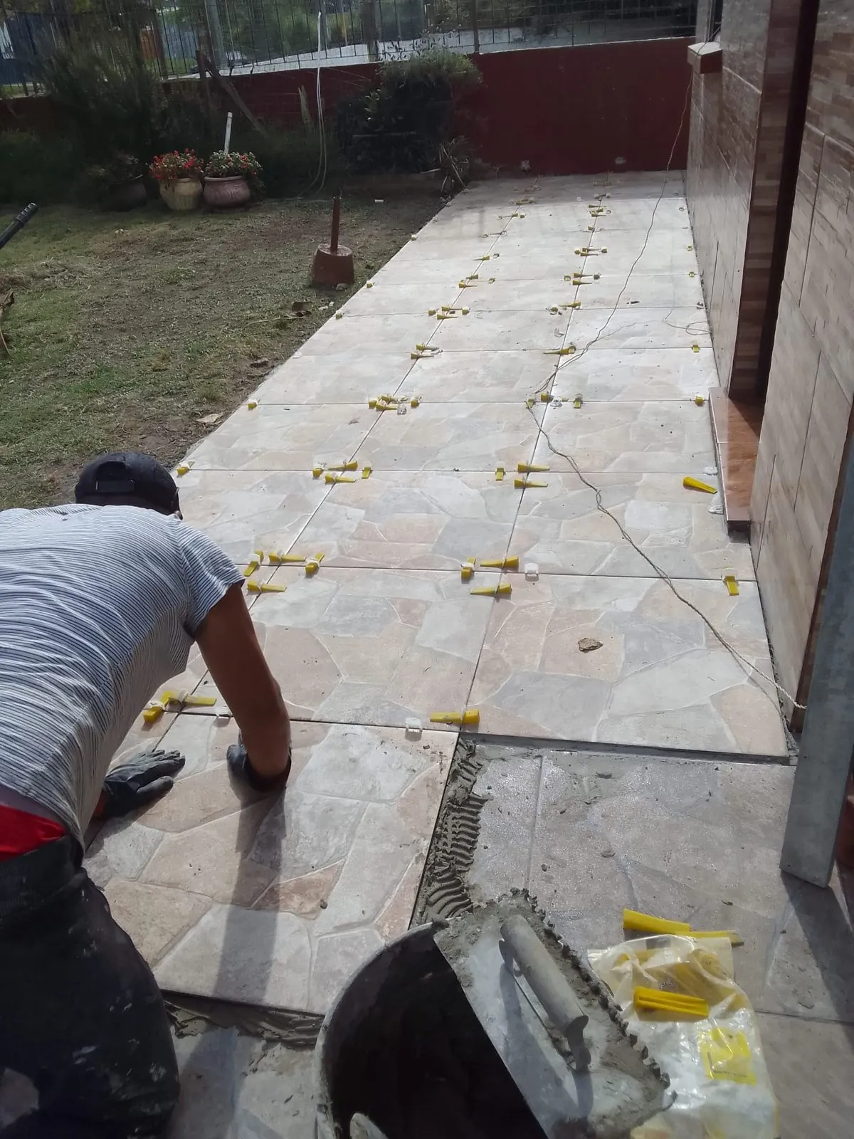 Operario colocando un solado de piedra natural irregular en un patio