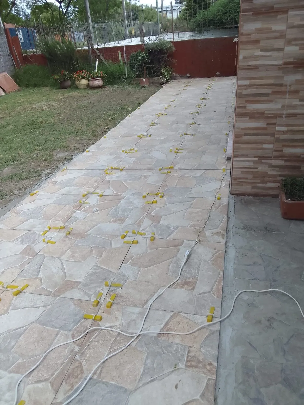 Paso lateral con solado de piedra natural y nivelación en curso
