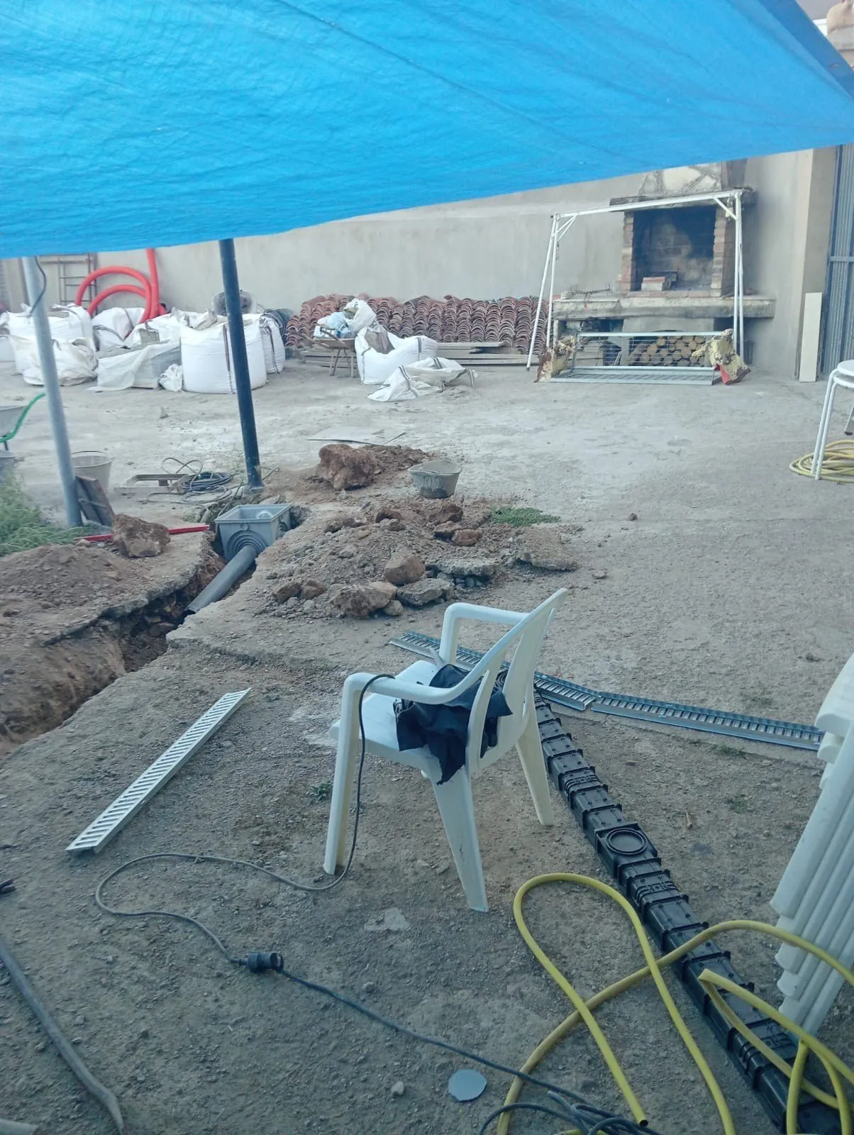 Zanja de instalaciones y canal de drenaje de rejilla en un patio, antes de hormigonar